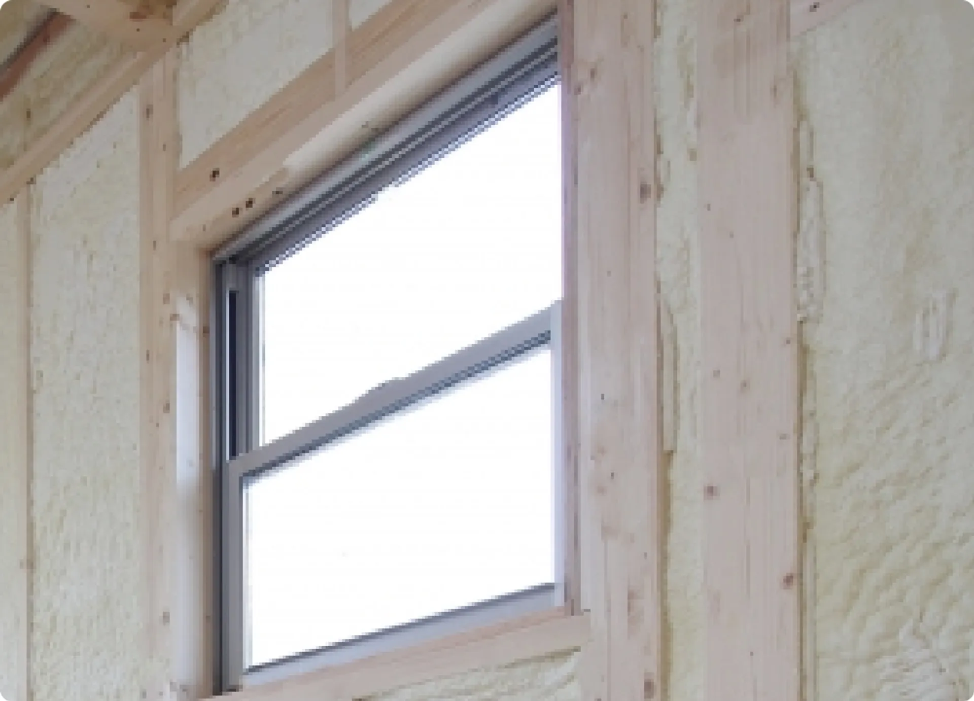 断熱性を高めるために複層ガラスの窓を設置している様子